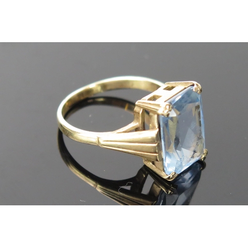 1058 - A 9ct Gold and Pale Blue Stone Cocktail Ring, baguette cut 13x11mm, stamped 9ct.