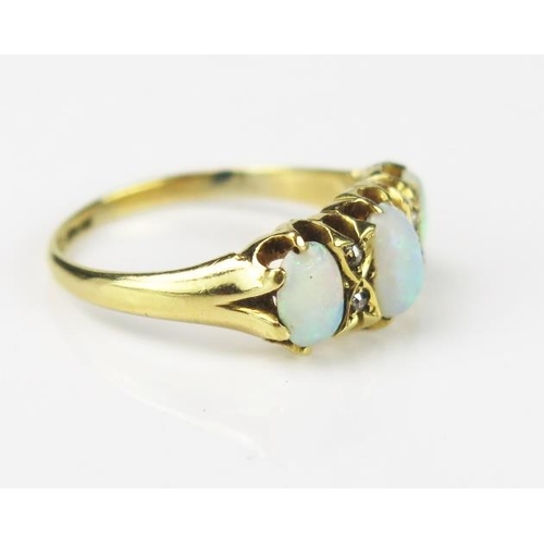 1059 - An Opal Three Stone and 18ct Gold Ring, the oval central stone flanked by two smaller stones, each w... 