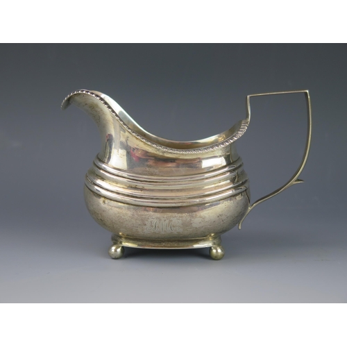 1116 - A George III silver cream jug, maker's mark worn, London, 1812, crested, of barge-shaped outline, wi... 