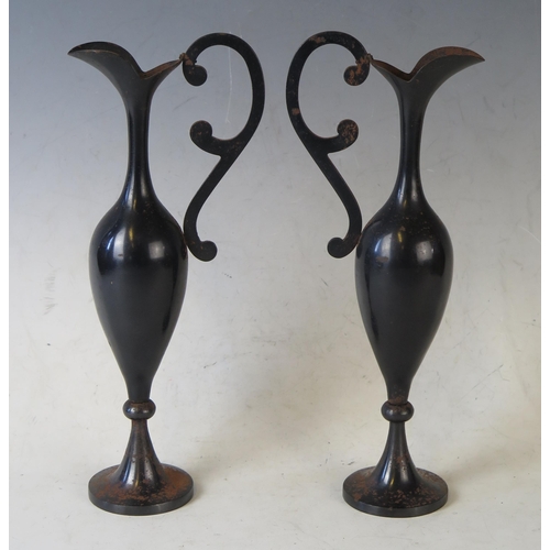 1684 - A pair of Iron and gilt decorated ewers, of slender baluster form, with scroll handles, having gilt ... 