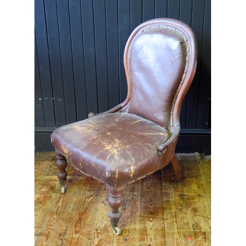 1687 - A Victorian mahogany spoon-back nursing chair, with padded back and stuff-over seat, on turned legs ... 