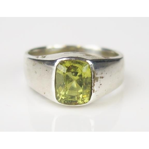 790 - A Yellow Stone and White Metal Ring, the central cushion cut stone in a signet style setting. size N... 