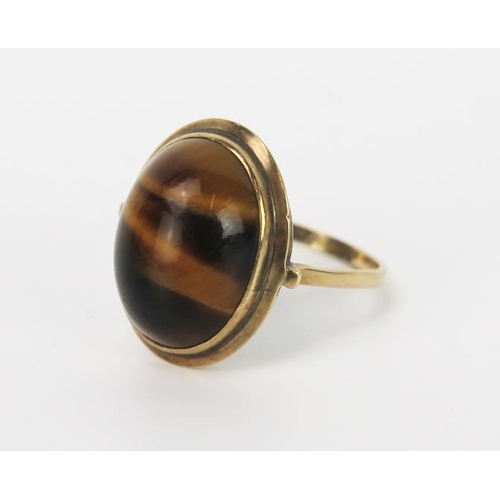 852 - A Tigers Eye and 9ct Gold Ring, the cabochon 17x13mm, ring size R/S, 4.6g