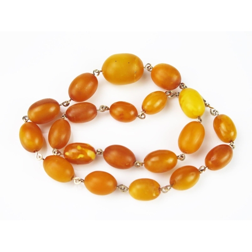 900 - A String of Baltic Butterscotch Amber Beads, united by gold plated links, 420mm long, 21.5g total.