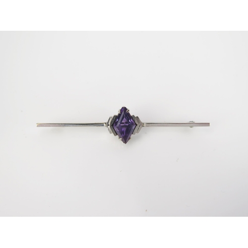 908 - An Art Deco Amethyst 9ct White Gold Bar Brooch, diamond cut stone, stamped 9ct, 5.5cm, 3.2g total.