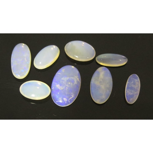 913 - A Group of Eight Cabochon Opals, mainly opaline, some color, largest 20x12mm showing purple, (8).