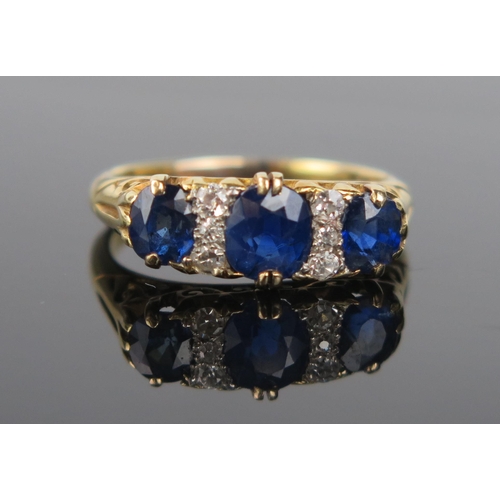 916 - A Sapphire, Diamond and 18ct Gold Ring, the central circular stone c. 5.7x5mm, flanked by six small ... 