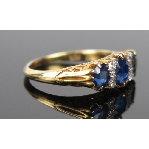 916 - A Sapphire, Diamond and 18ct Gold Ring, the central circular stone c. 5.7x5mm, flanked by six small ... 