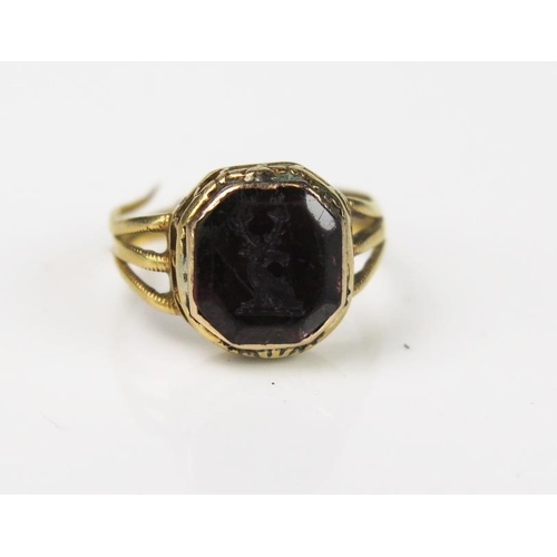 981 - An Antique Foil Back Amethyst and Gold Seal Ring, the 9mm stone with engraved stags head, set in an ... 