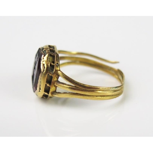 981 - An Antique Foil Back Amethyst and Gold Seal Ring, the 9mm stone with engraved stags head, set in an ... 