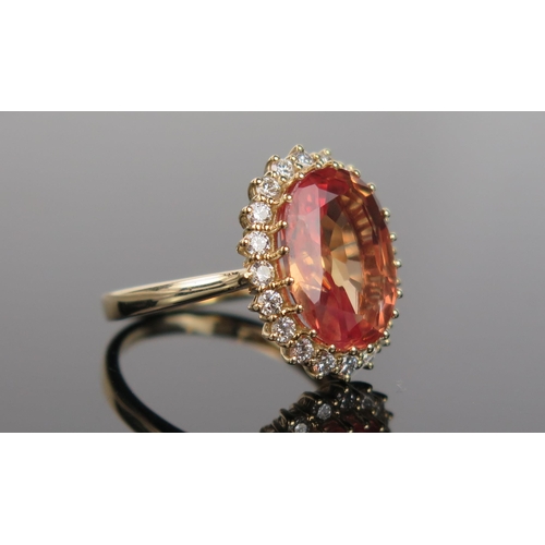 982 - A Mandarin or Orange Sapphire, Diamond and 14ct Gold Cocktail Ring, the pinkish orange central stone... 