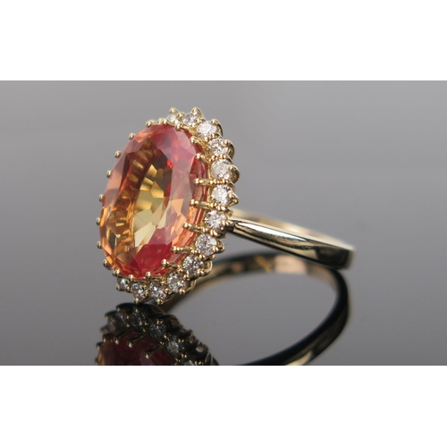 982 - A Mandarin or Orange Sapphire, Diamond and 14ct Gold Cocktail Ring, the pinkish orange central stone... 