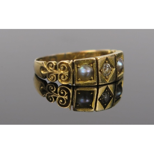 987 - A Victorian Diamond, Seed Pearl and 18ct Gold Three Stone Ring with scroll decoration to the shoulde... 