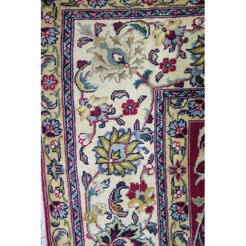 1339 - A Tabriz rug, the central wine red field with all over trailing foliage and flowerheads, enclosed by... 