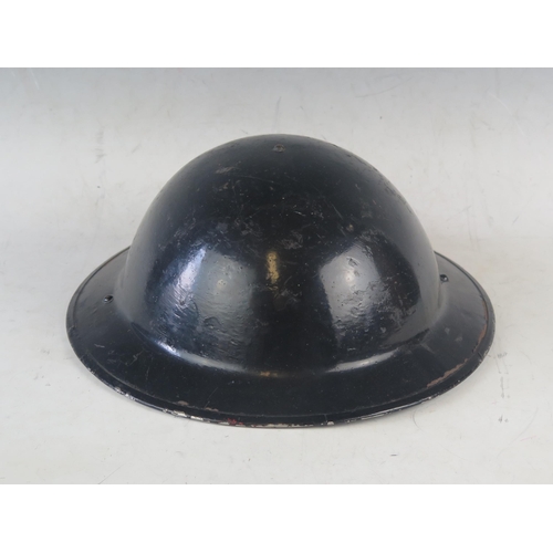 1037 - A WW2 period black painted steel helmet, with liner.