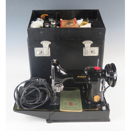 1084 - An early portable electric Singer sewing machine, model 221K1, in original box with papers and acces... 