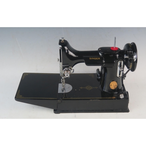 1084 - An early portable electric Singer sewing machine, model 221K1, in original box with papers and acces... 