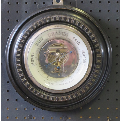 1129 - A wall mounted aneroid barometer, of circular outline contained in a mahogany frame, 23cm diameter.