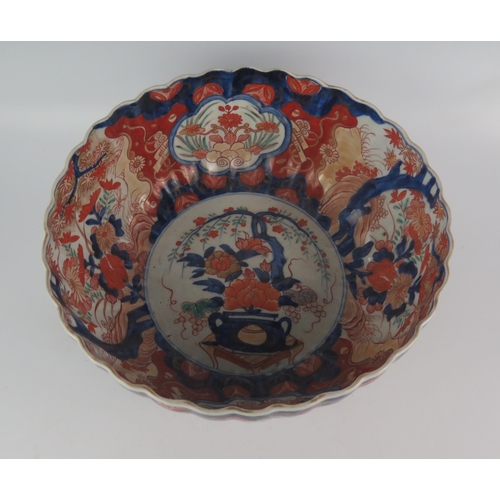 1156 - An Imari porcelain bowl of circular fluted form, with traditional decoration of foliate panels enclo... 