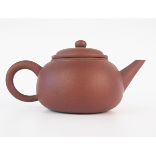 1173 - A Chinese Yixing teapot, of plain circular form with domed cover, impressed four character mark to t... 