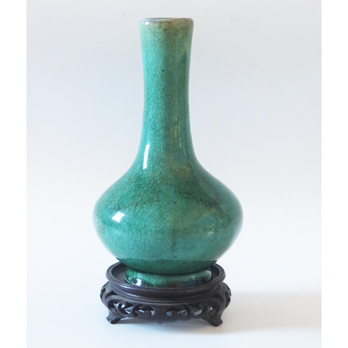1175 - A Chinese crackle glaze pottery bottle vase, with celadon green ground, having a slender neck a squa... 