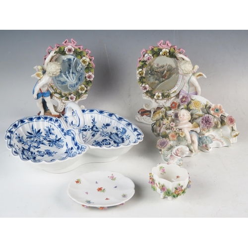 1231 - A pair of German porcelain easel mirrors in oval floral decorated frames supported to one side by cu... 