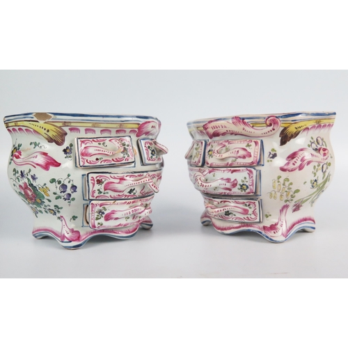 1245 - A pair of faience commodes of bombe-shaped outline, the tops bearing armorials enclosed by floral sp... 