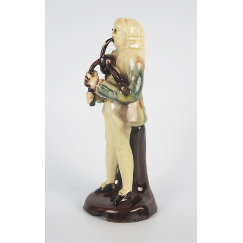 1246 - An 18th century Astbury-Whieldon pottery figure of a piper, with brown, blue and green treacle glaze... 