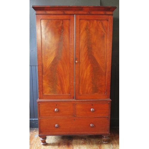 1307 - A 19th century mahogany linen press, with moulded cornice above a pair of plain field cupboard doors... 