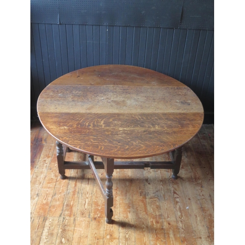 1309 - A late 18th century oak dining table, the oval top with two drop leaves, on turned and block legs wi... 