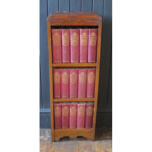 1312 - A 1920's oak bookcase containing fifteen volumes of the works of Charles Dickens. 31cm wide