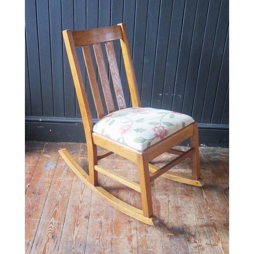 1319 - A light oak rocking chair, with slatted back and slip in swept, on swept rockers.