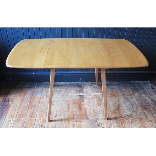 1323 - An Ercol dining table of rectangular outline with two drop leaves on square chamfered and tapering l... 