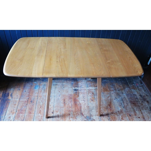 1323 - An Ercol dining table of rectangular outline with two drop leaves on square chamfered and tapering l... 