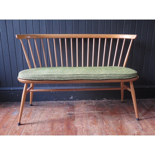 1324 - An Ercol love seat, the spindle back with cowhorn top rail, the solid seat with chamfered and wavy e... 