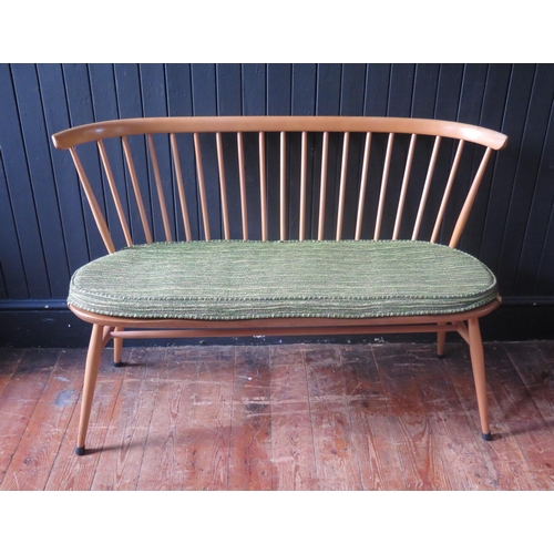 1324 - An Ercol love seat, the spindle back with cowhorn top rail, the solid seat with chamfered and wavy e... 