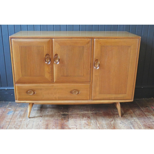 1327 - An Ercol sideboard of rectangular outline, containing an arrangement of a pair of cupboard doors a l... 