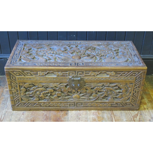 1332 - A Chinese carved camphor wood chest of rectangular outline, decorated with dragons chasing pearls of... 