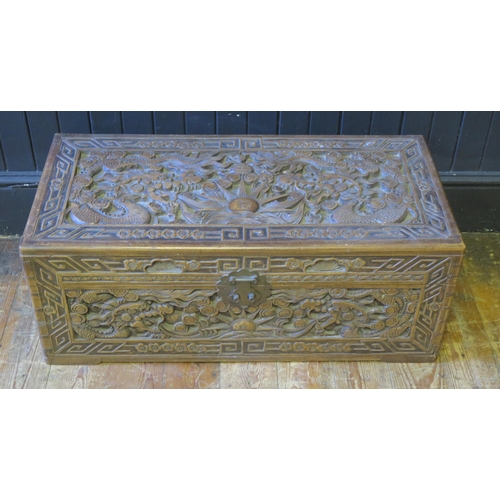 1332 - A Chinese carved camphor wood chest of rectangular outline, decorated with dragons chasing pearls of... 