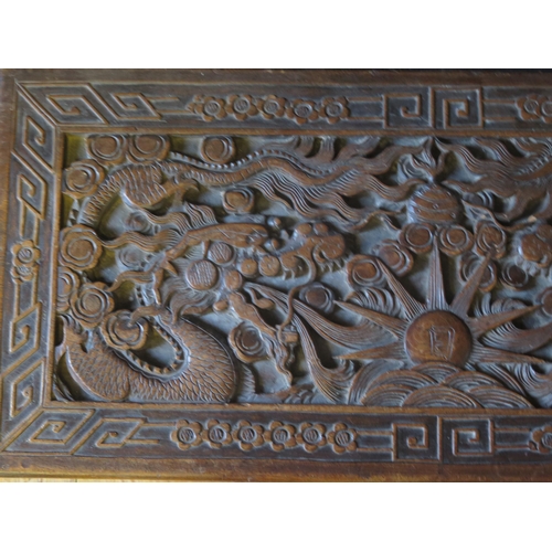 1332 - A Chinese carved camphor wood chest of rectangular outline, decorated with dragons chasing pearls of... 