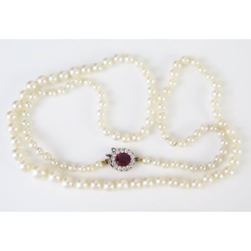 157 - A 21.5" Graduated Pearl Necklace (untested) with an unmarked gold, pigeon blood ruby and diamond cla...