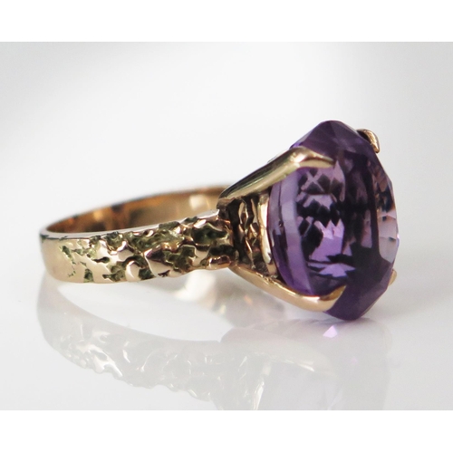 201 - An Unmarked Gold and Amethyst Cocktail Ring, 14.5x11.8mm claw set stone, textured shoulders, size K.... 