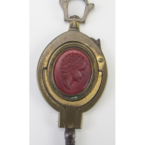 449 - A 19th Century Gilt Watch Key Fob with red stone matrix decorated with the bust of a young man in pr... 