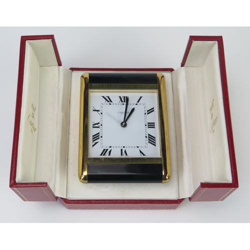 467 - A Boxed Cartier Quartz Easel Back Bedside Clock with alarm in a polished and brushed brass case with... 