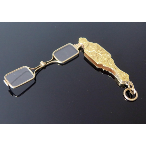 5 - An Antique Yellow Metal Lorgnette with chased foliate decoration, suspension loop and spring loaded ... 
