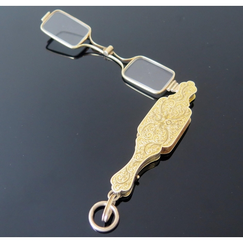 5 - An Antique Yellow Metal Lorgnette with chased foliate decoration, suspension loop and spring loaded ... 