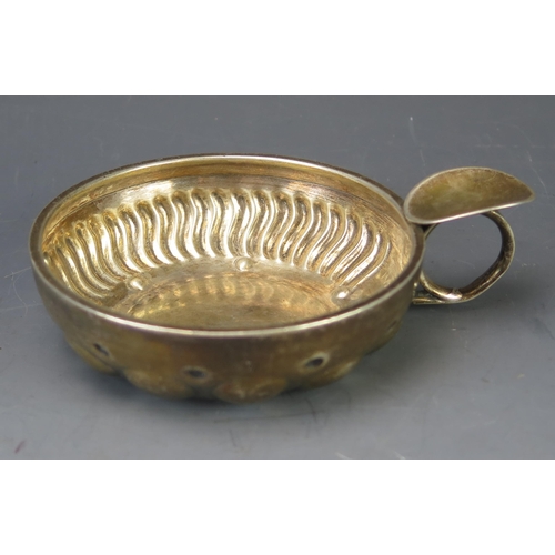 526 - A continental silver wine tasters bowl, of circular form with loop handle, 11.75cm wide, 108gms, 3.5... 