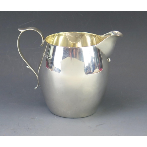 538 - A George VI silver cream jug, maker C.E, London, 1945, of ovoid form with capped scroll handle, 11cm... 