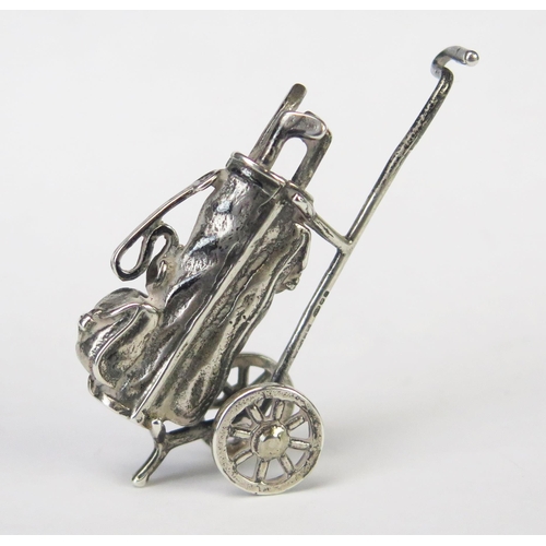 578 - A continental silver model of a miniature golf bag and trolley, bears import marks, 5.5cm long, 15gm... 