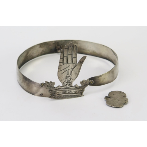 582 - A silver collar, unmarked, the band with chased floral decoration, the link in the form of a family ... 